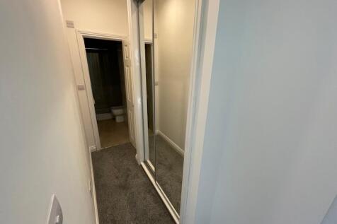A well-maintained hallway featuring a mirrored ...