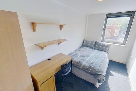 This cozy double bedroom features ample natural...