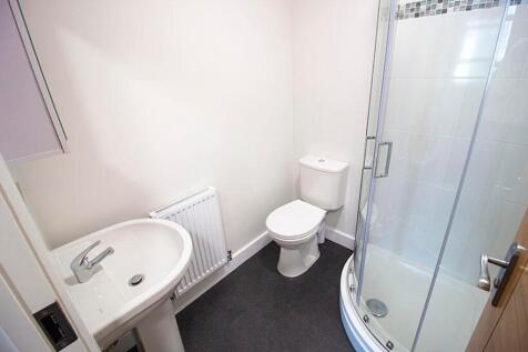 This modern bathroom features a spacious shower...