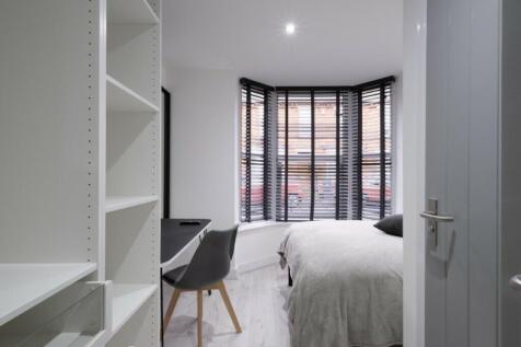 This inviting double bedroom features a cozy la...
