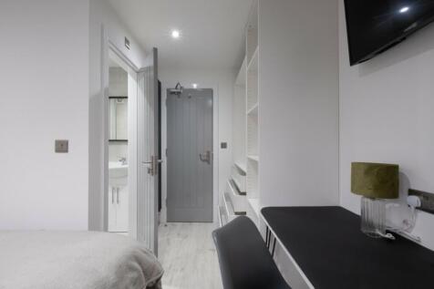 This inviting double bedroom features a cozy at...