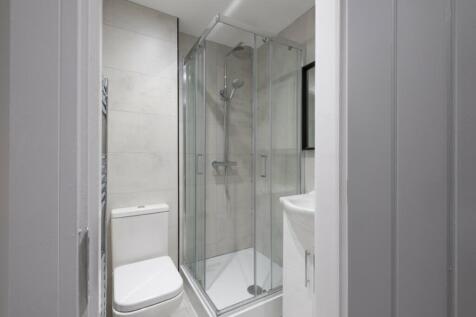 A modern bathroom featuring a sleek glass showe...