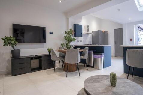 Modern kitchen space featuring stylish cabinetr...