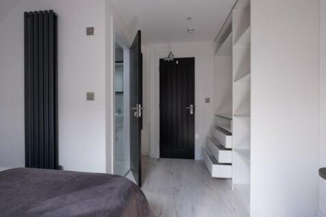 A bright and tidy double bedroom featuring mode...