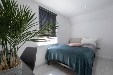 A bright and clean double bedroom featuring a c...