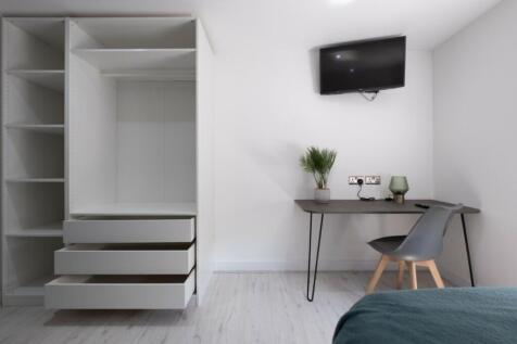 A spacious and bright double bedroom featuring ...