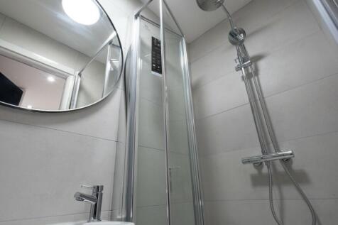 Modern bathroom featuring a sleek shower and el...