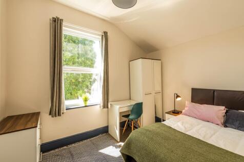 This inviting double bedroom features a comfort...