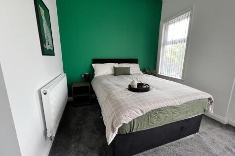 This inviting double bedroom features a modern ...