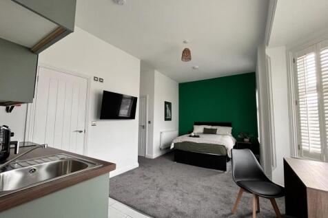 This inviting double bedroom features a cozy at...