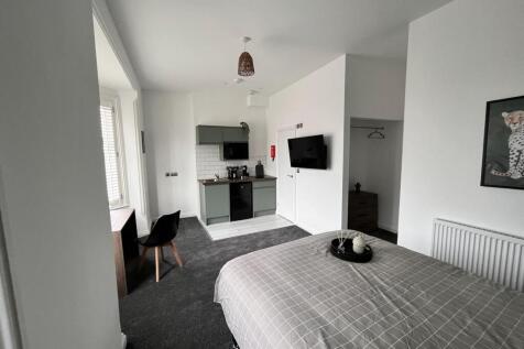 Spacious double bedroom featuring a cozy ambian...