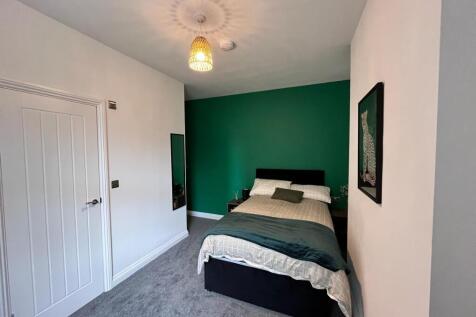 This inviting double bedroom features a cozy at...