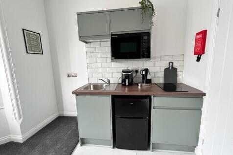Modern kitchenette featuring sleek cabinetry, e...