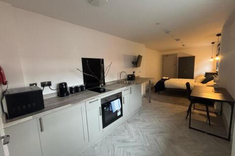 This modern kitchenette features sleek cabinetr...
