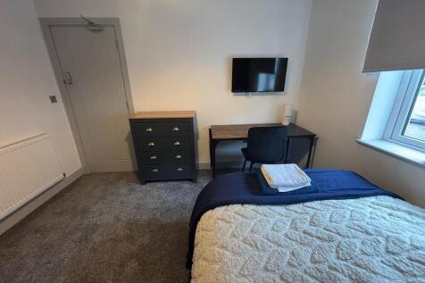 This cozy double bedroom features ample storage...
