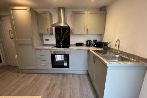 Modern kitchen featuring sleek cabinetry, ample...