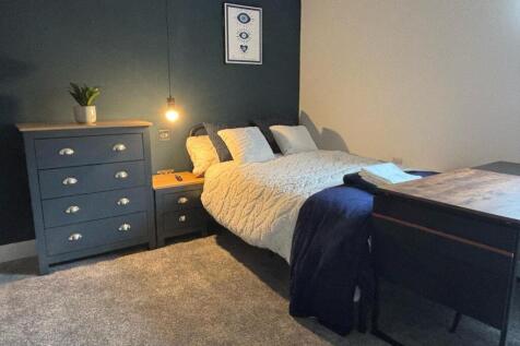 This cozy double bedroom features a comfortable...