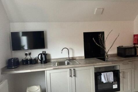 Modern kitchen featuring sleek cabinetry, ample...