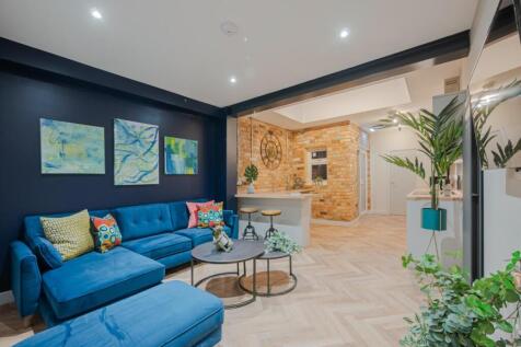 This stylish living room features a cozy seatin...