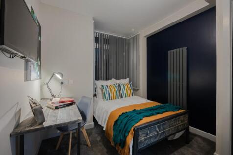 This stylish double bedroom features a cozy bed...