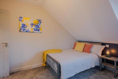 This cozy double bedroom features a comfortable...