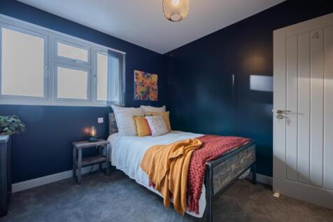 This inviting double bedroom features a cozy be...