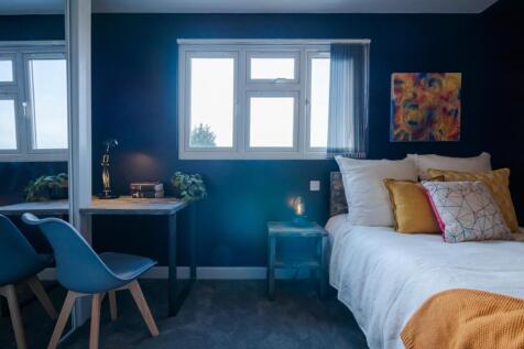 This inviting double bedroom features a cozy at...
