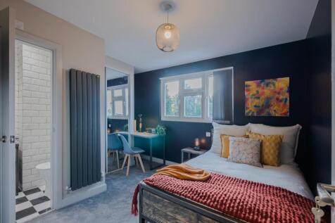 This stylish double bedroom features a cozy bed...