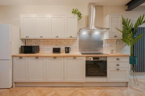Modern kitchen featuring sleek cabinetry, ample...