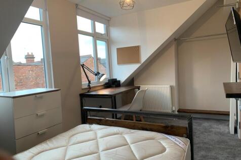 A bright and cozy double bedroom featuring larg...