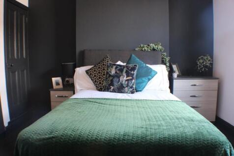 This inviting double bedroom features a cozy ar...