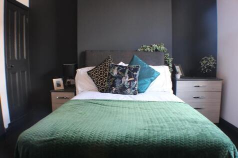 This inviting double bedroom features a comfort...