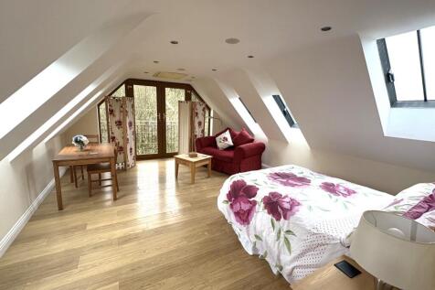 A spacious master bedroom featuring large windo...