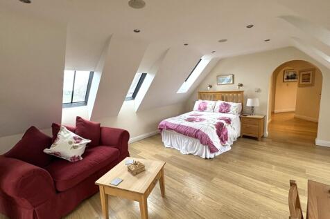 Spacious master bedroom featuring a cozy seatin...