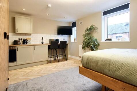 Spacious double bedroom featuring a cozy bed an...