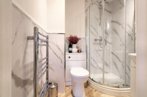 A modern bathroom featuring elegant marble wall...