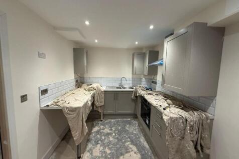 Spacious kitchen area featuring modern cabinetr...