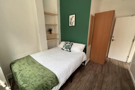 This inviting double bedroom features a cozy be...