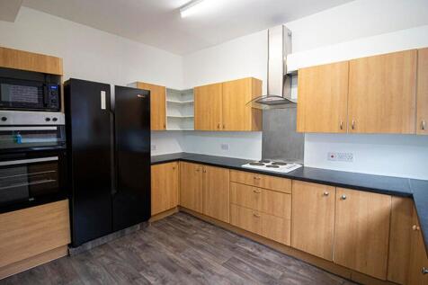 A modern kitchen featuring sleek wooden cabinet...