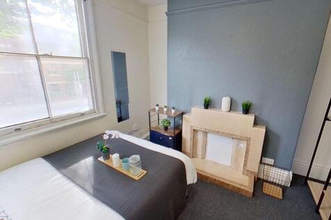 This charming double bedroom features a cozy at...
