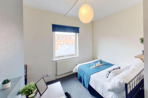 This inviting double bedroom features a cozy at...