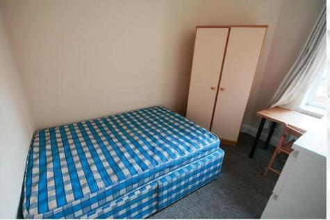 This cozy single bedroom features a comfortable...