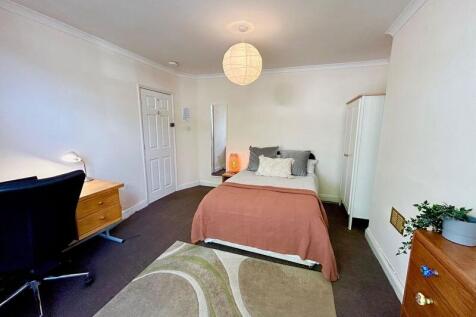 This inviting double bedroom features a comfort...