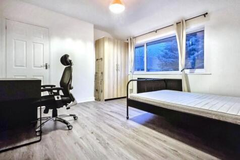 A spacious and well-lit double bedroom, perfect...