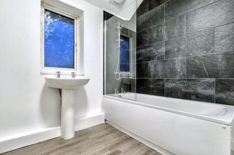 A spacious and modern bathroom featuring a rela...