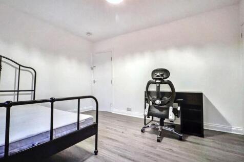 A spacious double bedroom with a modern desk an...