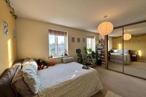 Spacious double bedroom featuring large windows...