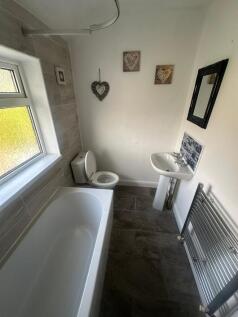 A bright and clean bathroom suite featuring a m...