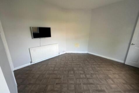 A spacious living room featuring neutral grey w...