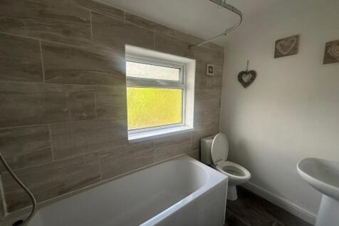 Bright and clean bathroom suite featuring a mod...